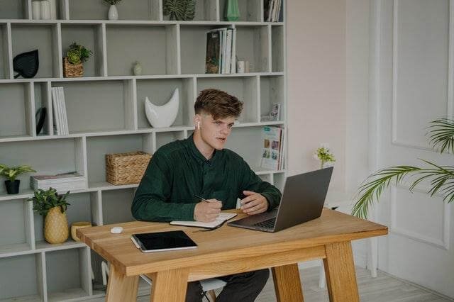 A person sitting at a desk with a computer

Description automatically generated with medium confidence