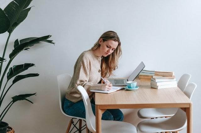 A person sitting at a table with a computer

Description automatically generated with low confidence